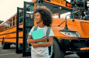 girl in front of school bus