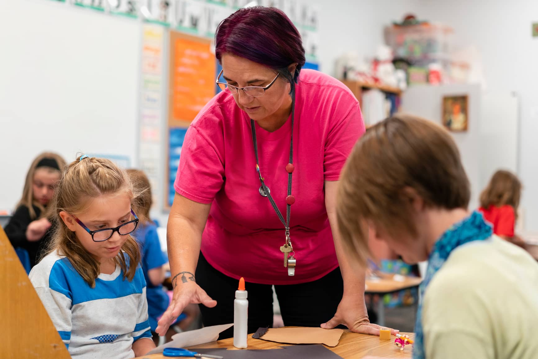 teacher helps students with art project