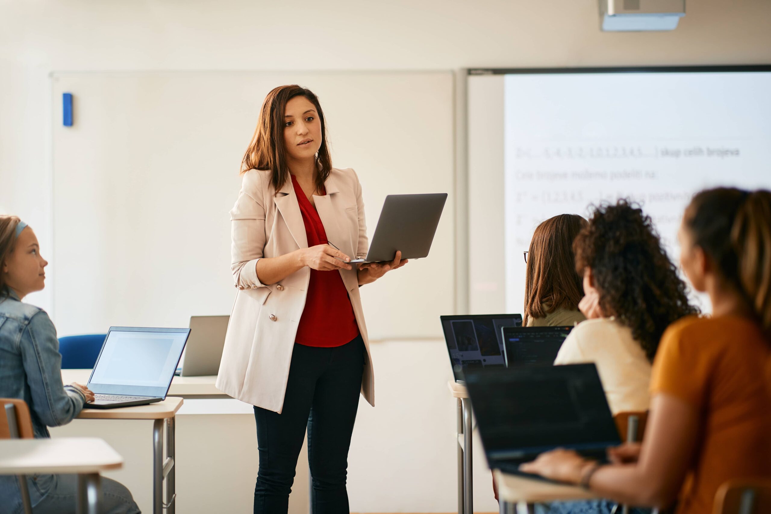 teacher with laptop speaks to class